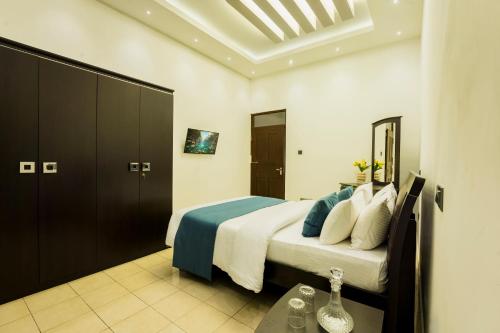 a bedroom with a bed with blue and white pillows at ThiThi's Palace Mirissa in Mirissa