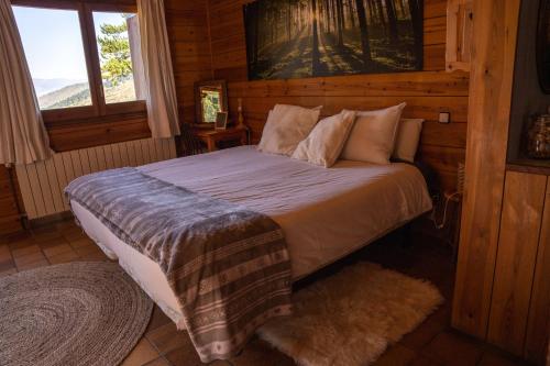 a bedroom with a bed in a log cabin at Minds & Mountains Eco Lodge in La Molina