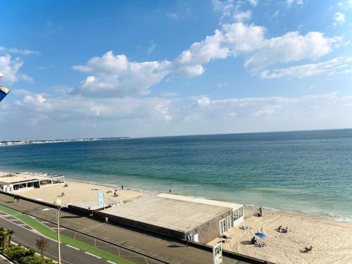 une vue d'une plage avec un bâtiment et l'océan dans l'établissement Studio en bord de mer avec terrasse, idéal pour 2 personnes - proche commerces et Casino, La Baule - FR-1-245-68, à La Baule