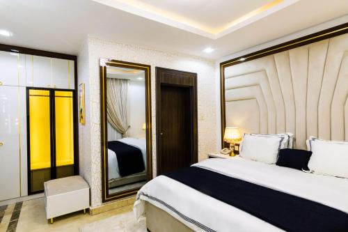 a bedroom with a large bed and a mirror at Yellow Trumpet Residence Asokoro in Asokoro