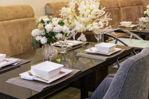 a dining room table with plates and flowers on it at Yellow Trumpet Residence Asokoro in Asokoro