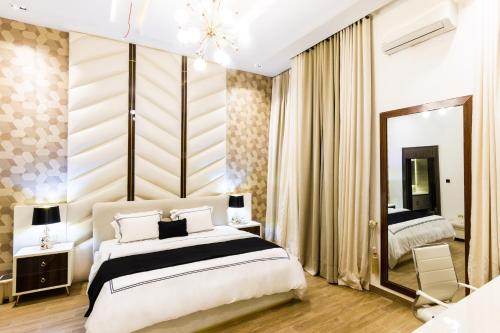 a bedroom with a large bed and a mirror at Yellow Trumpet Residence Asokoro in Asokoro
