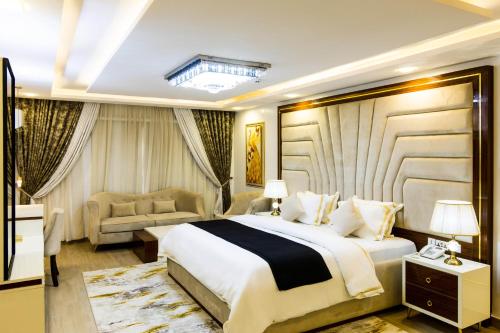 a hotel room with a large bed and a couch at Yellow Trumpet Residence Asokoro in Asokoro