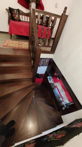 a staircase in a room with a red couch at Αρχοντικό Βαρσάνη ! in Anilio Metsovo