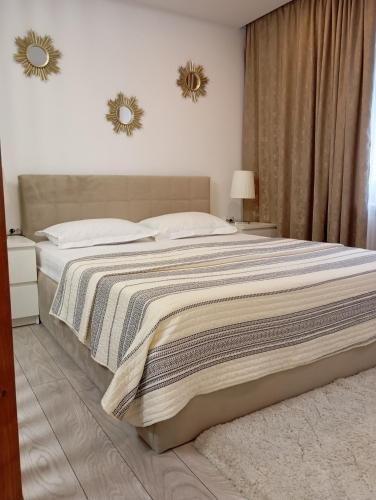 a bedroom with a large bed with two mirrors on the wall at Apartament General in Galaţi
