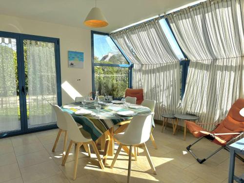 une salle à manger avec une table et des chaises dans l'établissement Maison lumineuse La Forêt-Fouesnant proche plage, golf, avec salle de détente et 5 chambres - FR-1-481-158, à La Forêt-Fouesnant