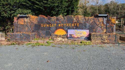 a sign for a sunburst retreat is on a rock wall at Sunset Retreats The Anna Mae in Worcester