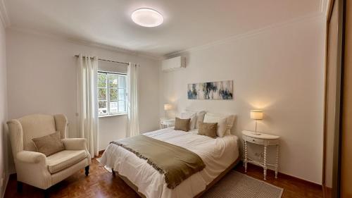 une chambre blanche avec un lit et une chaise dans l'établissement Pine Cliffs by Check-in Portugal, à Albufeira