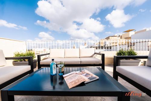 - une table avec une bouteille de vin sur le balcon dans l'établissement The Florian Boutique Guesthouse by Zzzing, à Cospicua