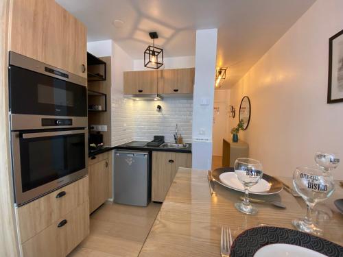 une cuisine et une salle à manger avec une table et des verres à vin dans l'établissement Clochette next to Disneyland Paris 5 PAX, à Montévrain