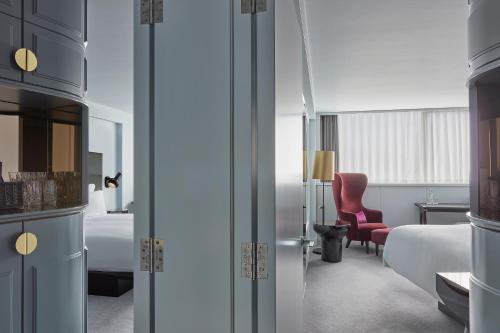 a hotel room with two beds and a red chair at Sea Containers London in London