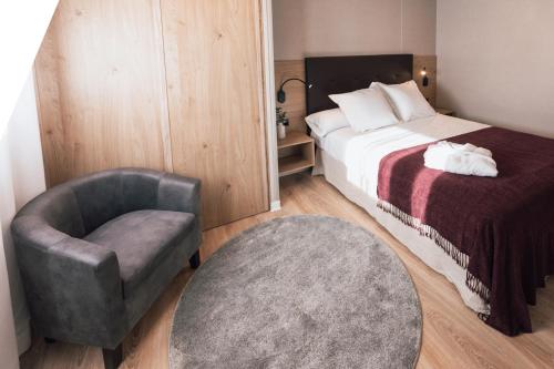 une chambre d'hôtel avec un lit et une chaise ainsi qu'un lit et une chaise dans l'établissement Natura Resorts, à Casalarreina