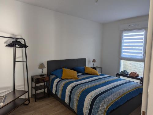 une chambre avec un lit avec des oreillers bleus et jaunes dans l'établissement Aux phoques rieurs, à Berck-sur-Mer