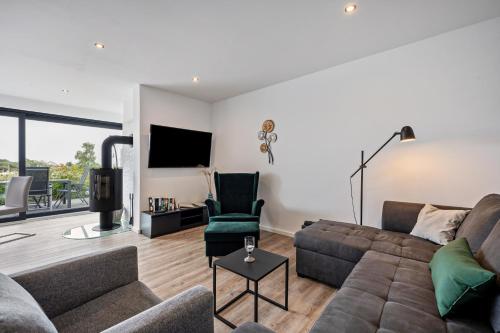 a living room with a couch and a tv at Ferienbungalow Süssau in Süssau