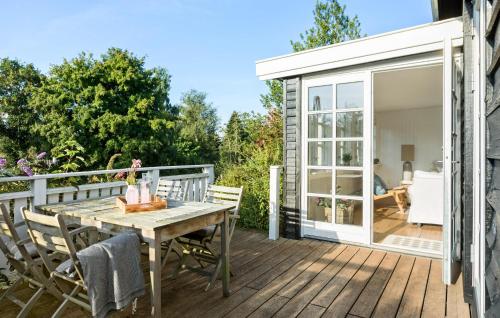 a patio with a table and chairs on a deck at 3 Bedroom Awesome Home In Hornbæk in Hornbæk