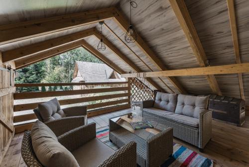 a living room with a couch and chairs in a cabin at Osada Pienińska in Krościenko