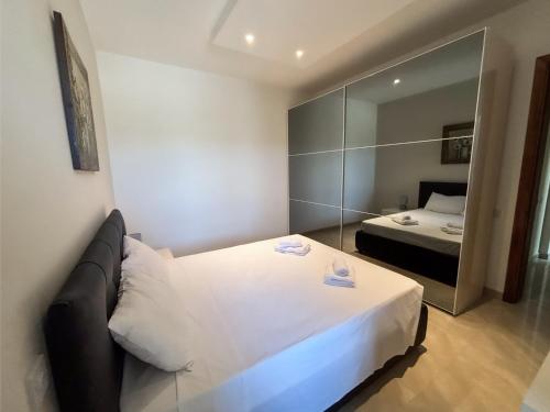 a small room with a bed and a mirror at Fort Chambray Holiday Villas & Apartments in Mġarr