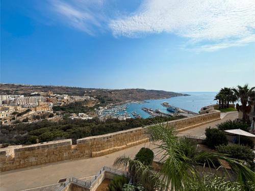 a view of a city and a body of water at Fort Chambray Holiday Villas & Apartments in Mġarr