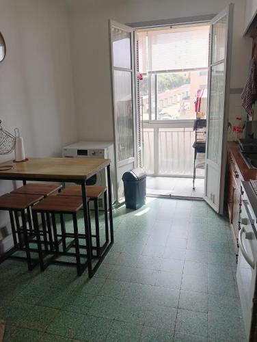 Il dispose d'un balcon et d'une cuisine avec une table et des chaises. dans l'établissement Chambres chez l'habitant, à Ajaccio