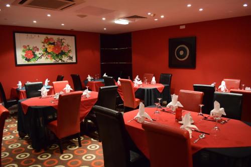 a conference room with red walls and tables and chairs at Best Western Palace Hotel & Casino in Douglas