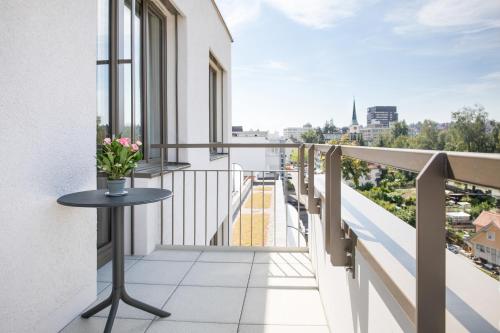 a balcony with a table and a view of the city at VISIONAPARTMENTS St Gallen - contactless check-in in St. Gallen