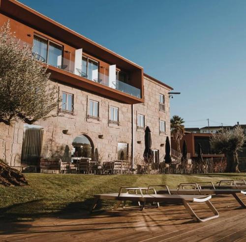 a building with tables and chairs in front of it at Quinta de Santo António - Country House & Villas in Marco de Canaveses