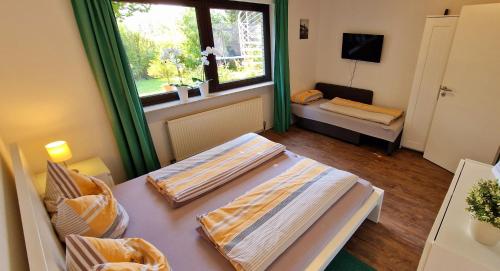 a small room with two beds and a window at Ferienwohnung am Parkwohnstift in Bad Kissingen