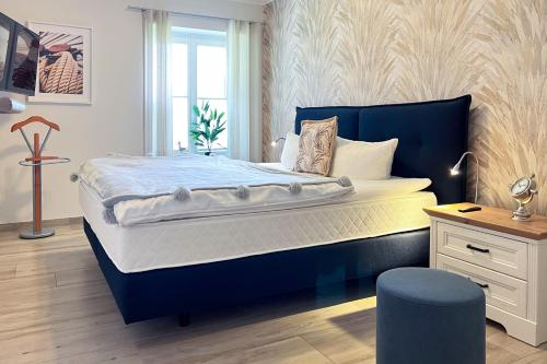 a bedroom with a large bed with a blue headboard at FeWo Muschelsucher in Wustrow