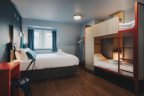a bedroom with two bunk beds and a desk at Kabannas Liverpool in Liverpool