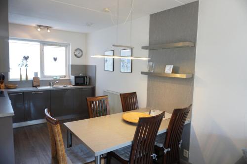 a kitchen and dining room with a table and chairs at Kustverhuur, Vakantiepark Fort Soleil 24 in Breskens