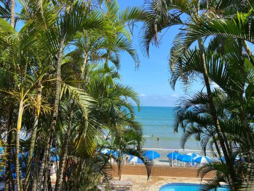 a view of a beach with palm trees and the ocean at Kaliman Pousada in Ubatuba