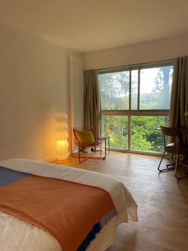 une chambre avec un lit et une grande fenêtre dans l'établissement Chavot la Bulle - Architect house in Champagne, à Chavot-Courcourt