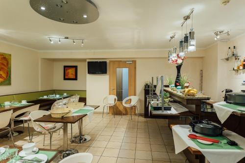 a restaurant with tables and chairs in a room at Hotel Andra München in Munich