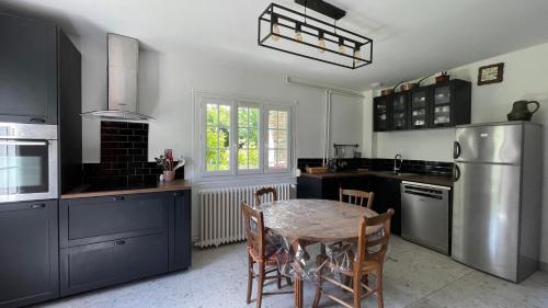 une cuisine avec une table et des chaises dans l'établissement Les Bruyeres, maison proche mer, à Hautot-sur-Mer