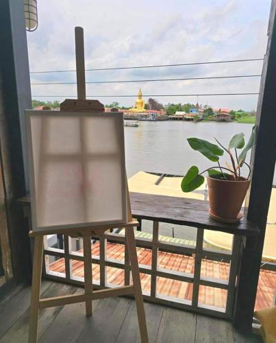 a chair sitting on a porch with a view of the water at เฉื่อย โฮมสเตย์ in Nonthaburi