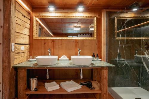 a bathroom with two sinks and a mirror at Der Gannerhof in Innervillgraten