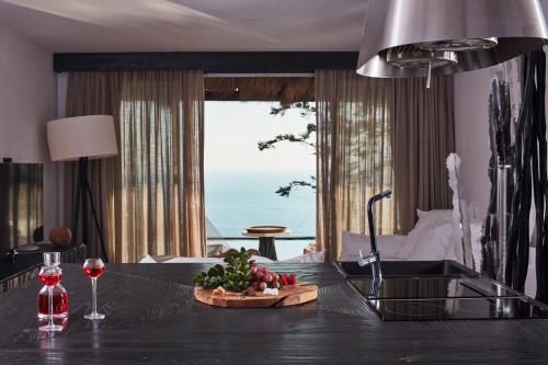 a kitchen with a table with a bowl of fruit on it at Myconian Utopia Relais & Chateaux in Elia Beach