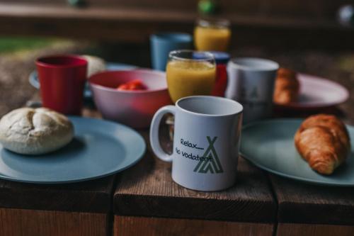 a table with plates of food and a coffee mug at Camping Het Horstmannsbos in Gasselte