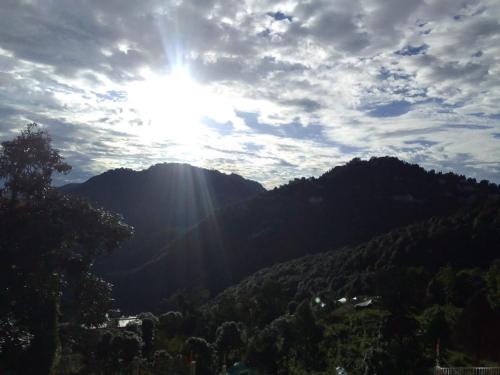 a sun shining on top of a mountain at Saadhan Homestay in Mussoorie