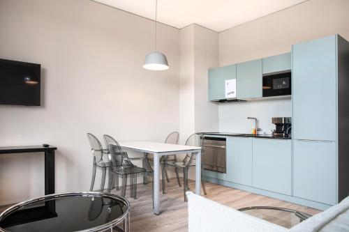 a kitchen and dining room with a table and chairs at VISIONAPARTMENTS St Gallen - contactless check-in in St. Gallen