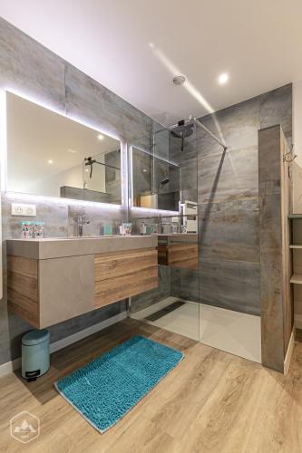 une salle de bains avec douche, lavabo et miroir dans l'établissement L'Autentic, à Aussois