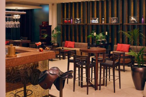 a bar with tables and chairs in a restaurant at Meliá Desert Palm Member of Meliá Collection in Dubai