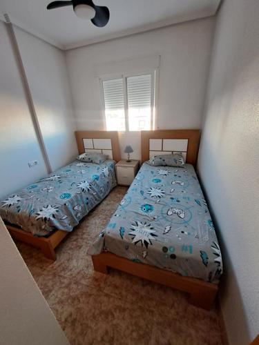 sypialnia z dwoma łóżkami i oknem w obiekcie orihuela costa - torrevieja w mieście Orihuela