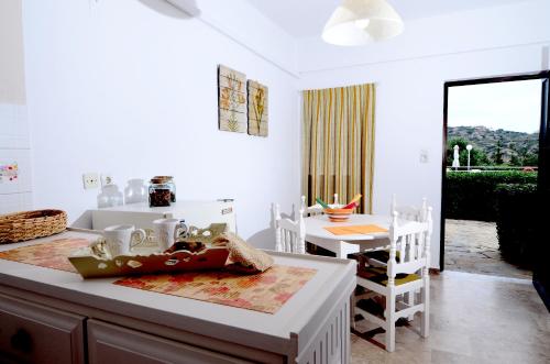 a white kitchen with a table and a dining room at Golden Apartments in Agios Nikolaos