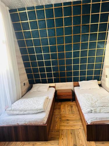 two beds in a room with a wall at Forest House in Vǝndam
