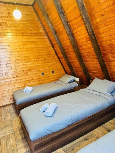 two beds in a room with wooden walls at Forest House in Vǝndam