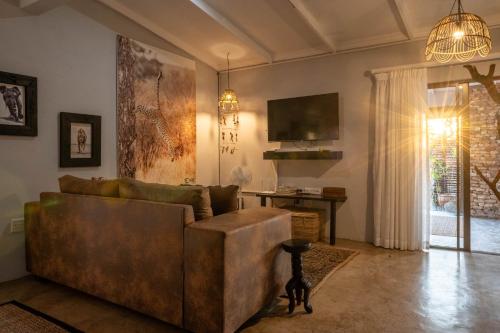 a living room with a couch and a table at Foxy Crocodile Bush Lodge & Kruger Safari's - No Loadshedding in Marloth Park