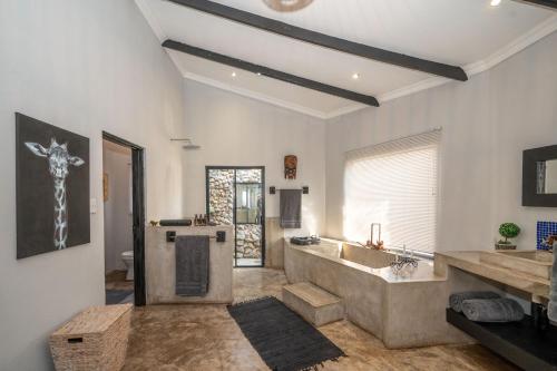 a large bathroom with a tub and a sink at Foxy Crocodile Bush Lodge & Kruger Safari's - No Loadshedding in Marloth Park