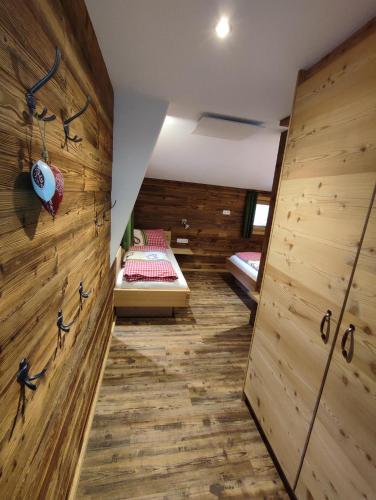 ヴェステンドルフにあるFerienhaus Straussのベッド付きの木製の壁の客室です。