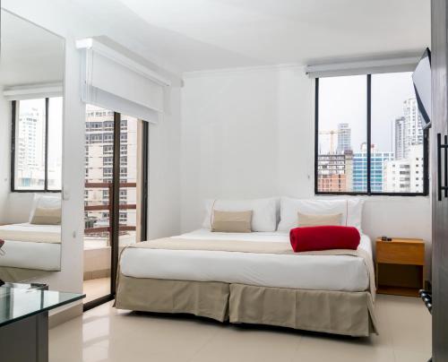 a bedroom with a large bed with a red pillow at Zalmedina Hotel in Cartagena de Indias